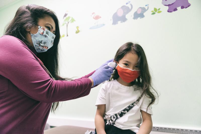 a young girl getting her ear examined